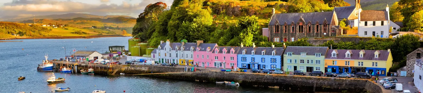 Petit port aux maisons colorées au bord d’une baie, bateaux au mouillage