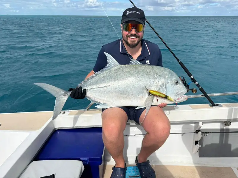 Pêcheur tenant un gros poisson à bord d’un bateau